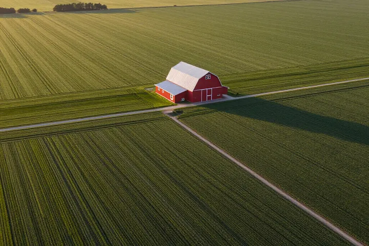 Farmstead with barn and fields at sunset